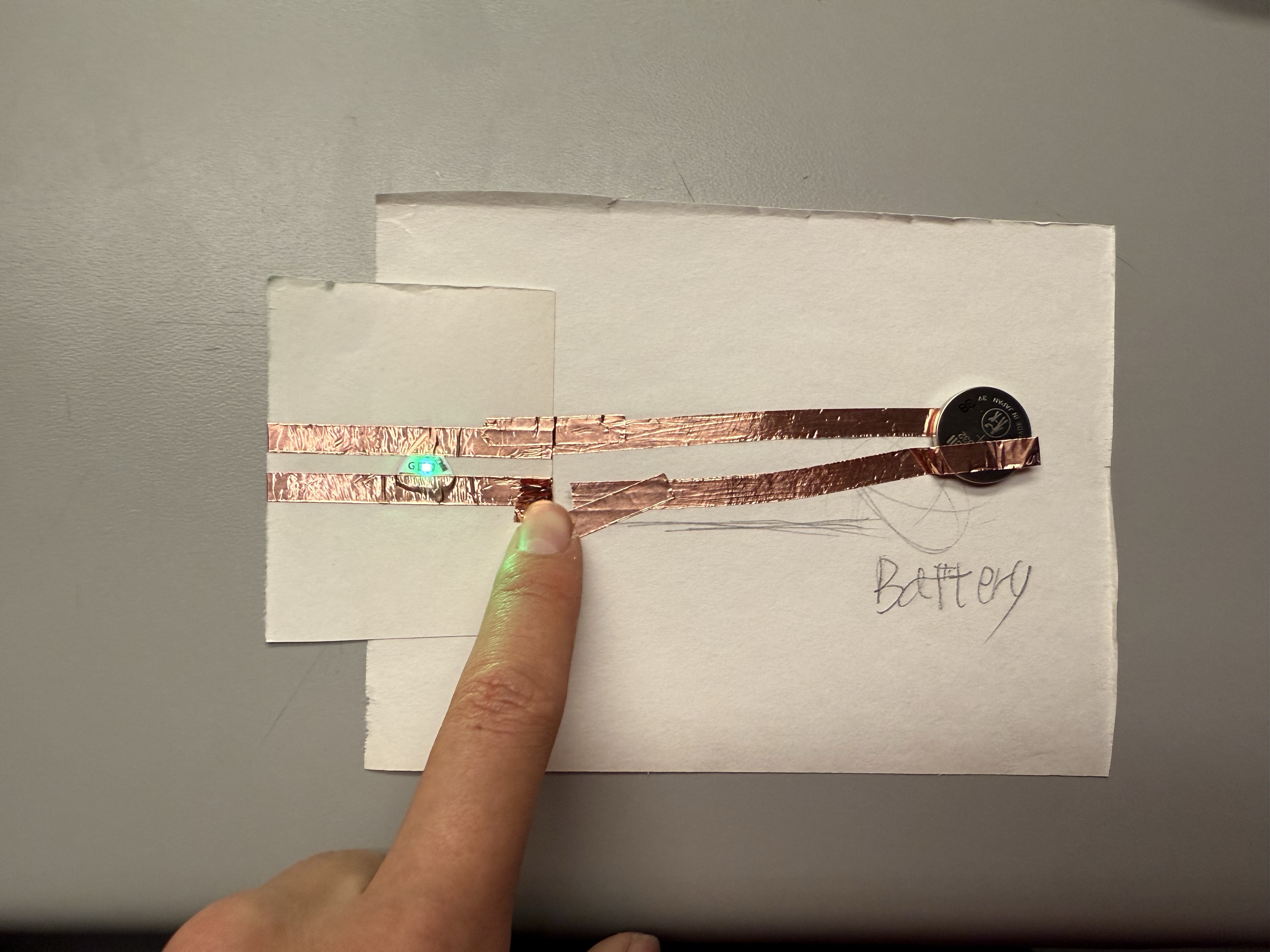 Demonstration of connecting a coin battery to light up an LED sticker.