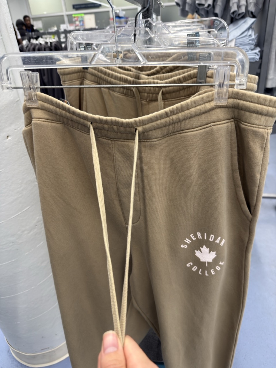 person pulling up a pair of pants by gripping the waistband and adjusting them into position.