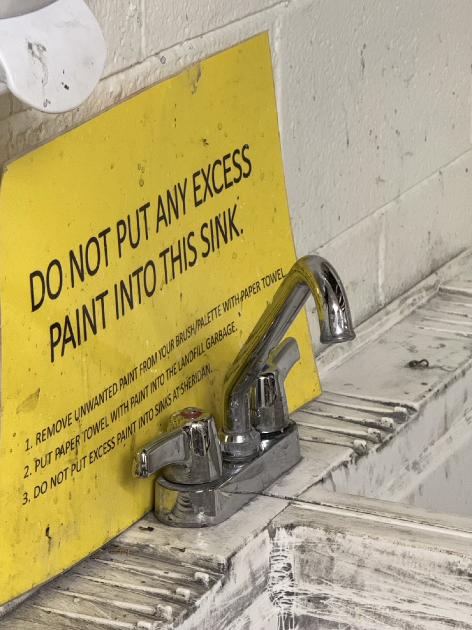 Close-up of a hand turning a tap handle.