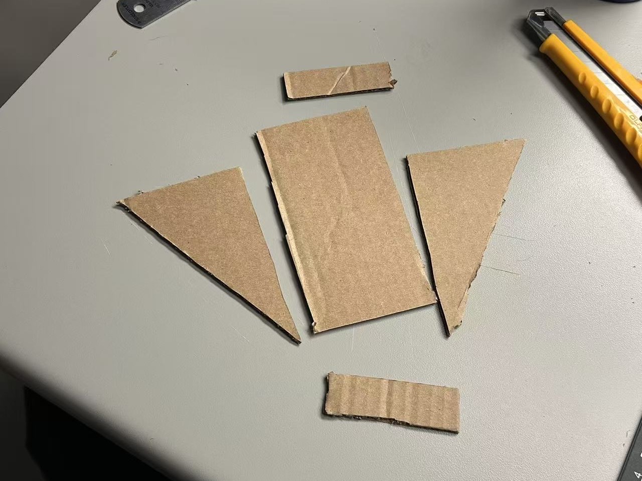 Cut cardboard parts — base, ribs, slot pieces