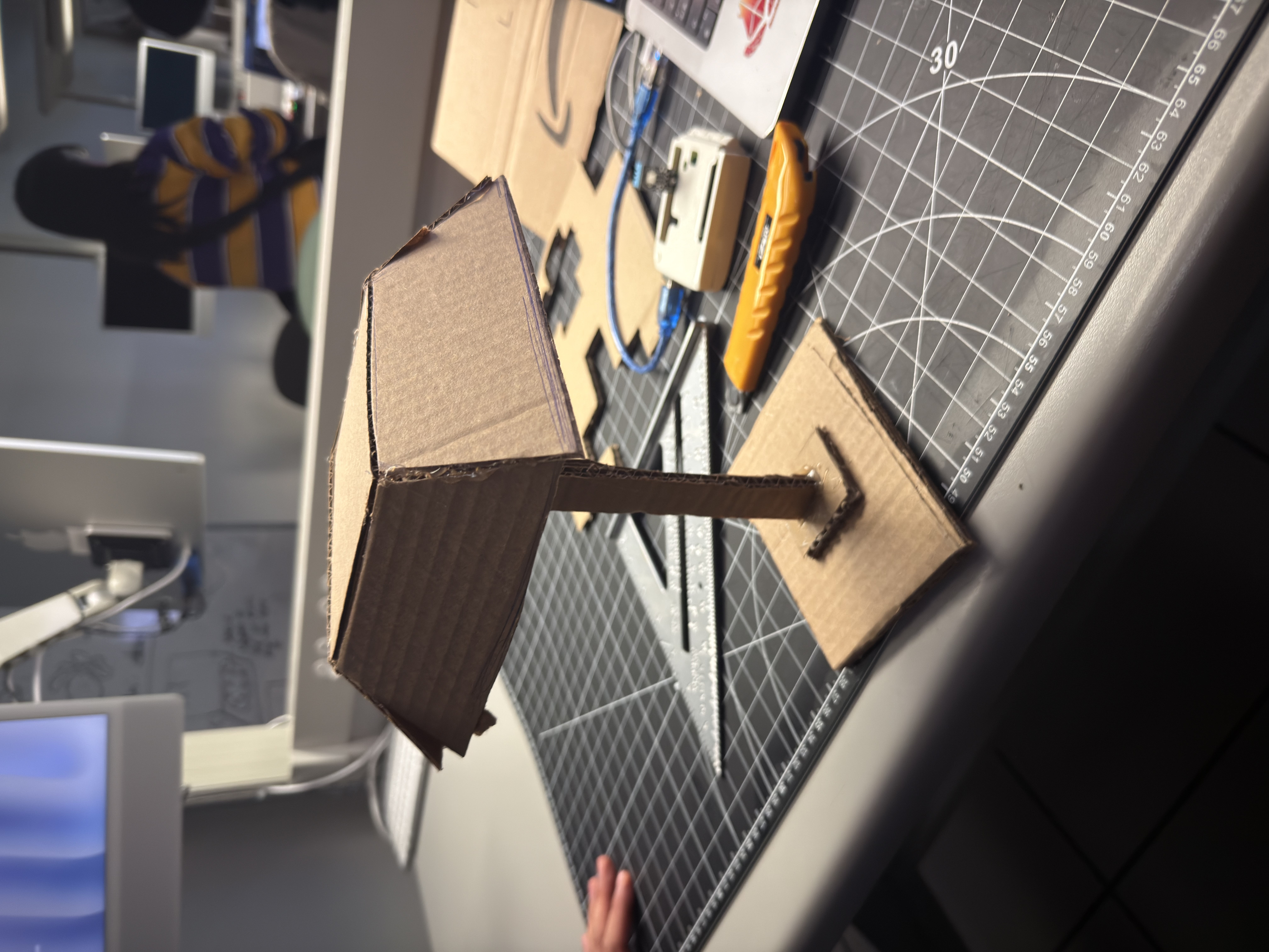 Step 3 — V2 stability upgrade: larger base and added support on the load side; shade attachment strengthened. Result: lateral sway is reduced and the model stays put during desk use. Next: improve cable routing and fine-angle adjustability.